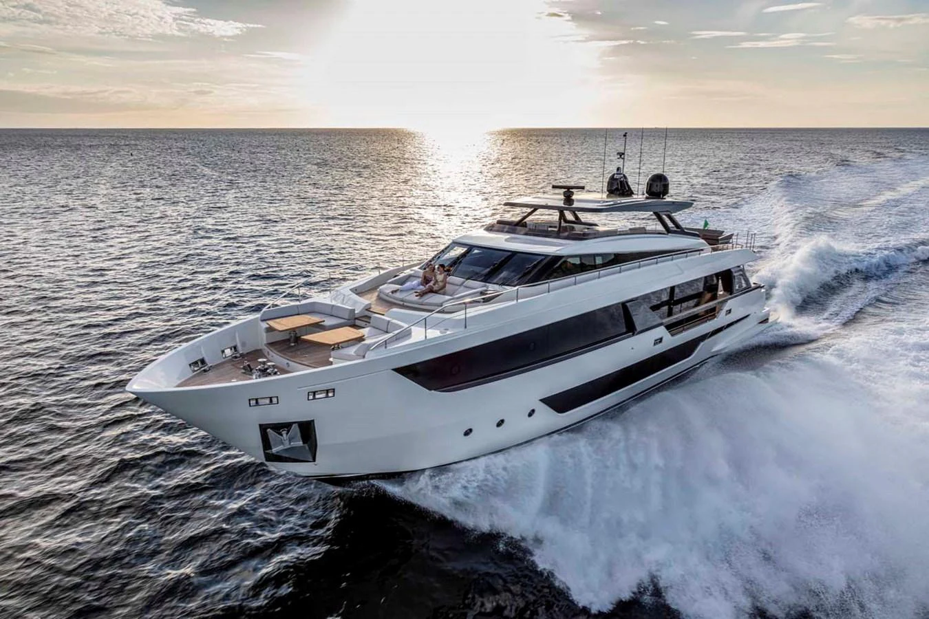 A sleek and modern yacht cruises through the open water at sunset. aboard EPIC Yacht for Sale