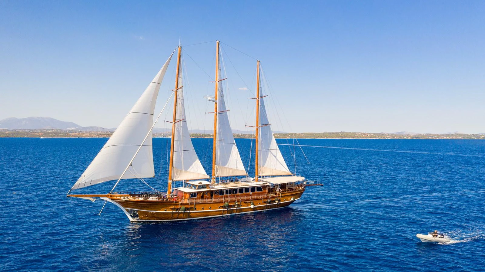 A majestic sailing yacht glides through the open sea with its sails fully unfurled. aboard THALASSA Yacht for Sale