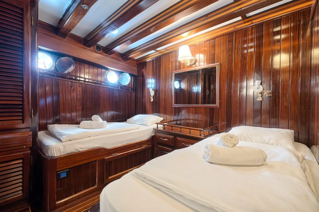 The guest cabin features twin beds with warm wooden paneling and soft lighting. aboard THALASSA Yacht for Sale