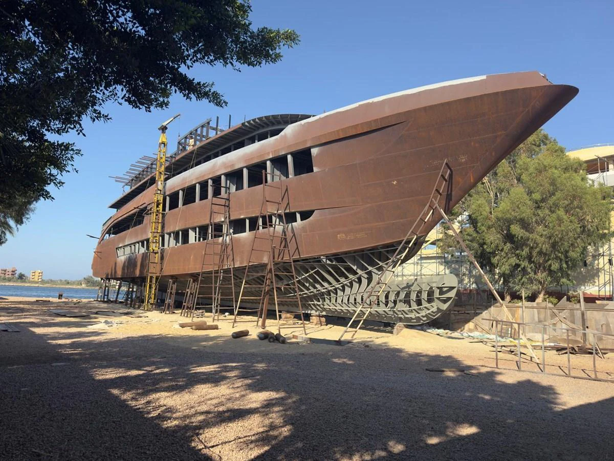 A yacht under construction, showcasing its large, unfinished hull on a dry dock. aboard OSKAR ONE Yacht for Sale