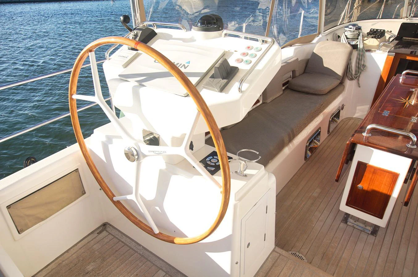 The helm station features a large wooden steering wheel and modern navigation equipment. aboard RAGNAR Yacht for Sale