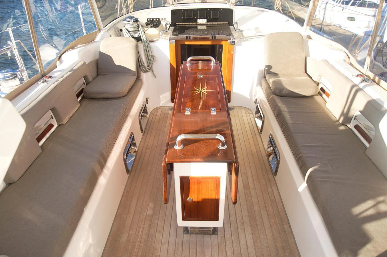 The cockpit features comfortable seating with a central wooden table, perfect for socializing and relaxation. aboard RAGNAR Yacht for Sale
