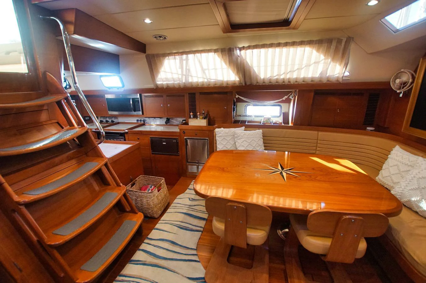 The yacht's dining area features a polished wooden table with comfortable seating and ample natural light. aboard RAGNAR Yacht for Sale