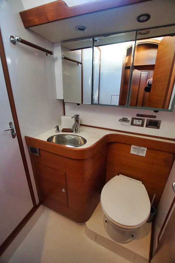 The yacht's head features a compact and functional design with wooden accents and modern fixtures. aboard RAGNAR Yacht for Sale