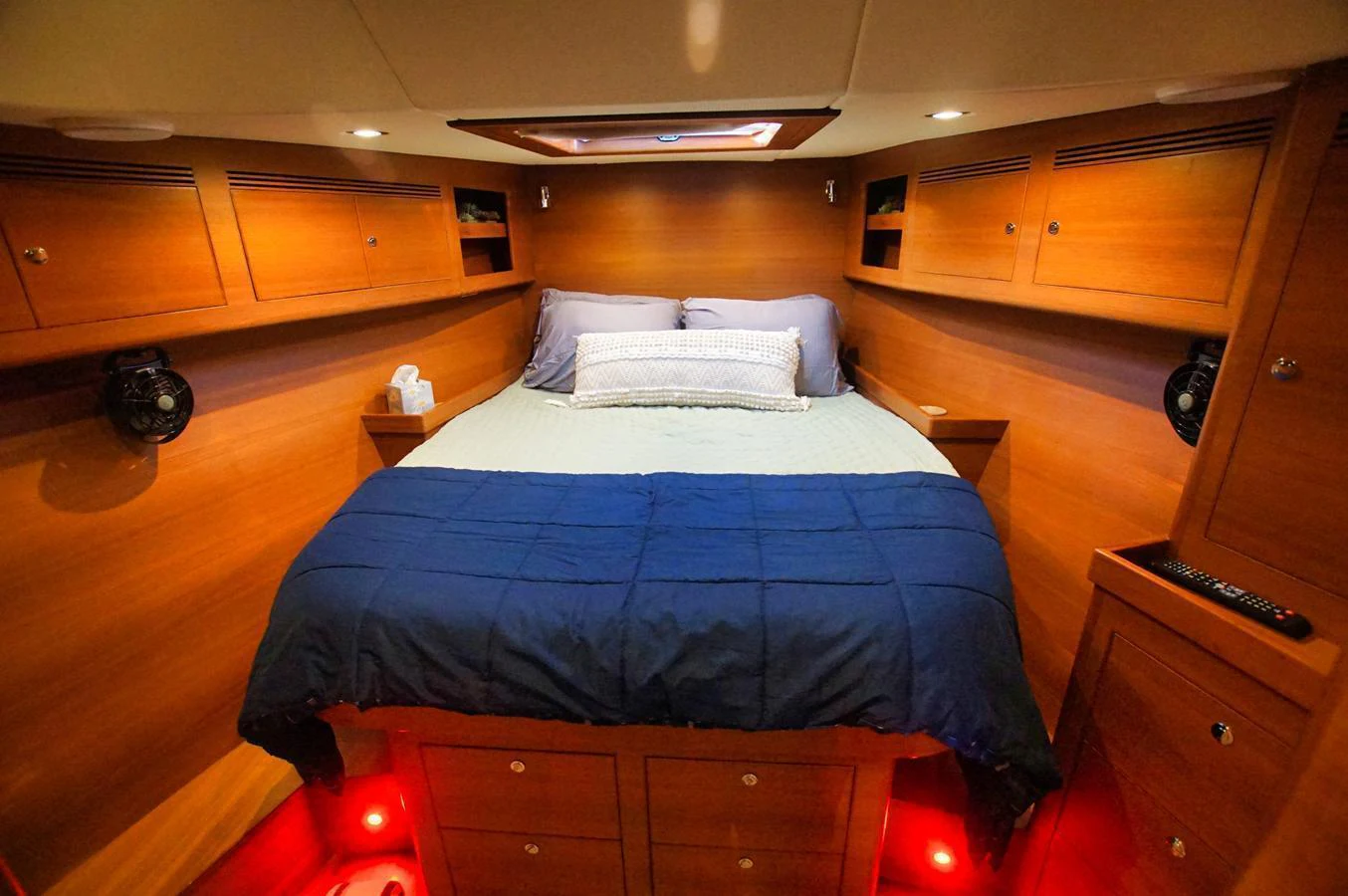 A cozy stateroom with warm wood paneling and ambient lighting. aboard RAGNAR Yacht for Sale