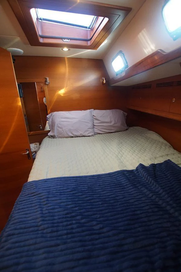 A cozy stateroom with a skylight and warm wooden finishes. aboard RAGNAR Yacht for Sale