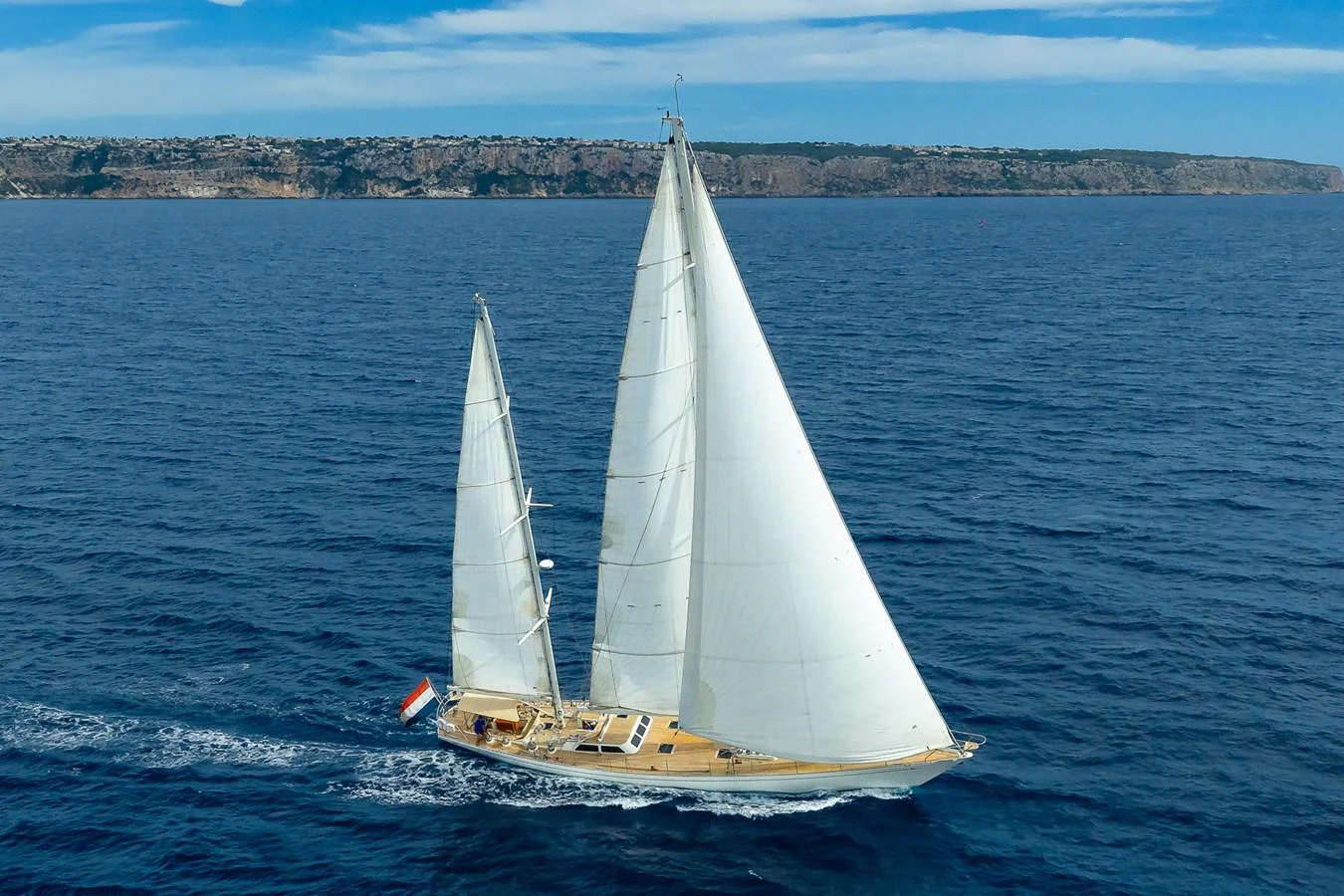 A stunning sailing yacht glides gracefully on the open sea with its sails fully unfurled. aboard TEMPEST Yacht for Sale