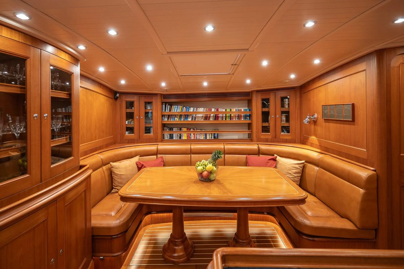 The yacht's dining area features a warm, inviting space with wooden furnishings and a cozy atmosphere. aboard TEMPEST Yacht for Sale