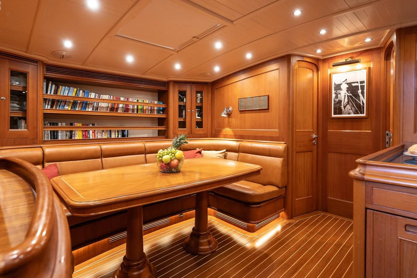 The yacht's dining area features rich wood finishes and a cozy, inviting atmosphere. aboard TEMPEST Yacht for Sale