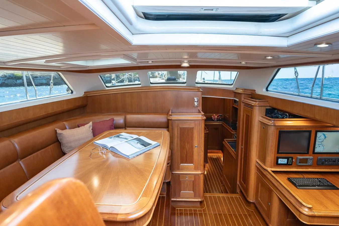 The yacht's saloon features elegant wood finishes, a spacious dining area, and ample natural light through large windows. aboard TEMPEST Yacht for Sale