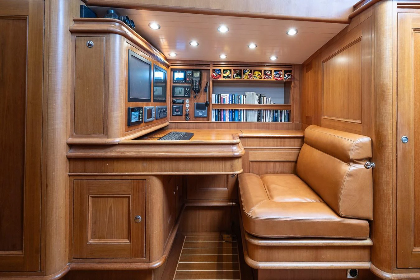 The yacht's office area features rich wood paneling and a comfortable leather seating arrangement. aboard TEMPEST Yacht for Sale