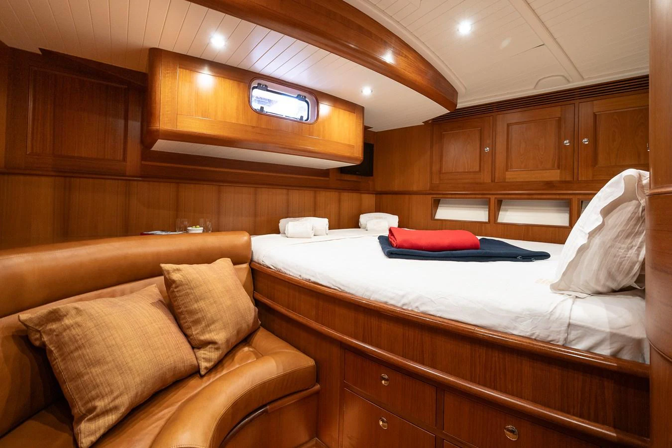A cozy stateroom featuring a comfortable bed and warm wooden finishes. aboard TEMPEST Yacht for Sale