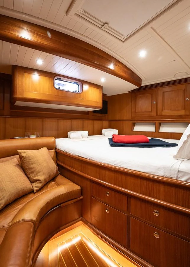 A cozy stateroom with warm wood finishes and a comfortable bed. aboard TEMPEST Yacht for Sale