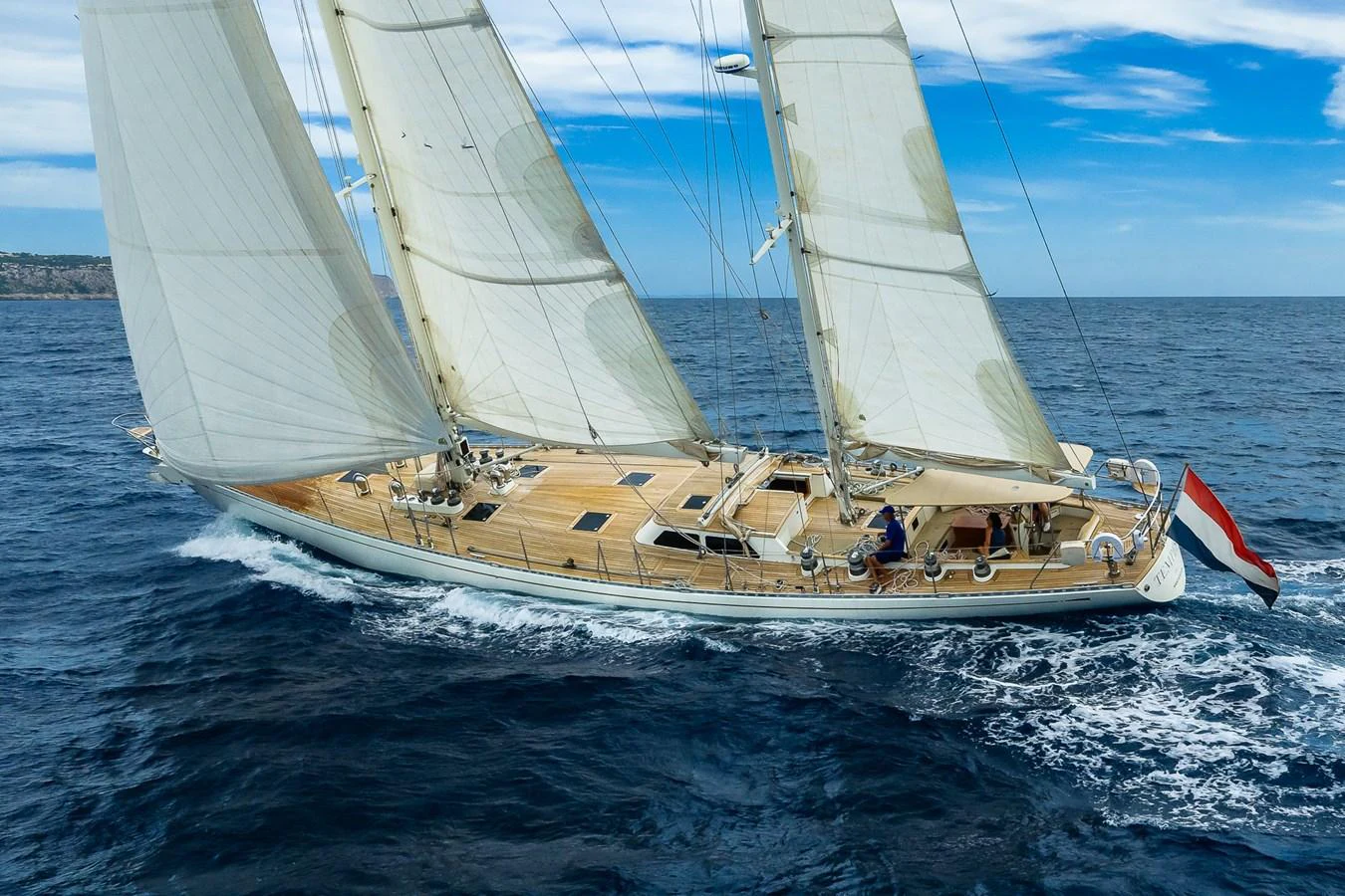 A stunning sailing yacht glides gracefully on the open sea under full sail. aboard TEMPEST Yacht for Sale