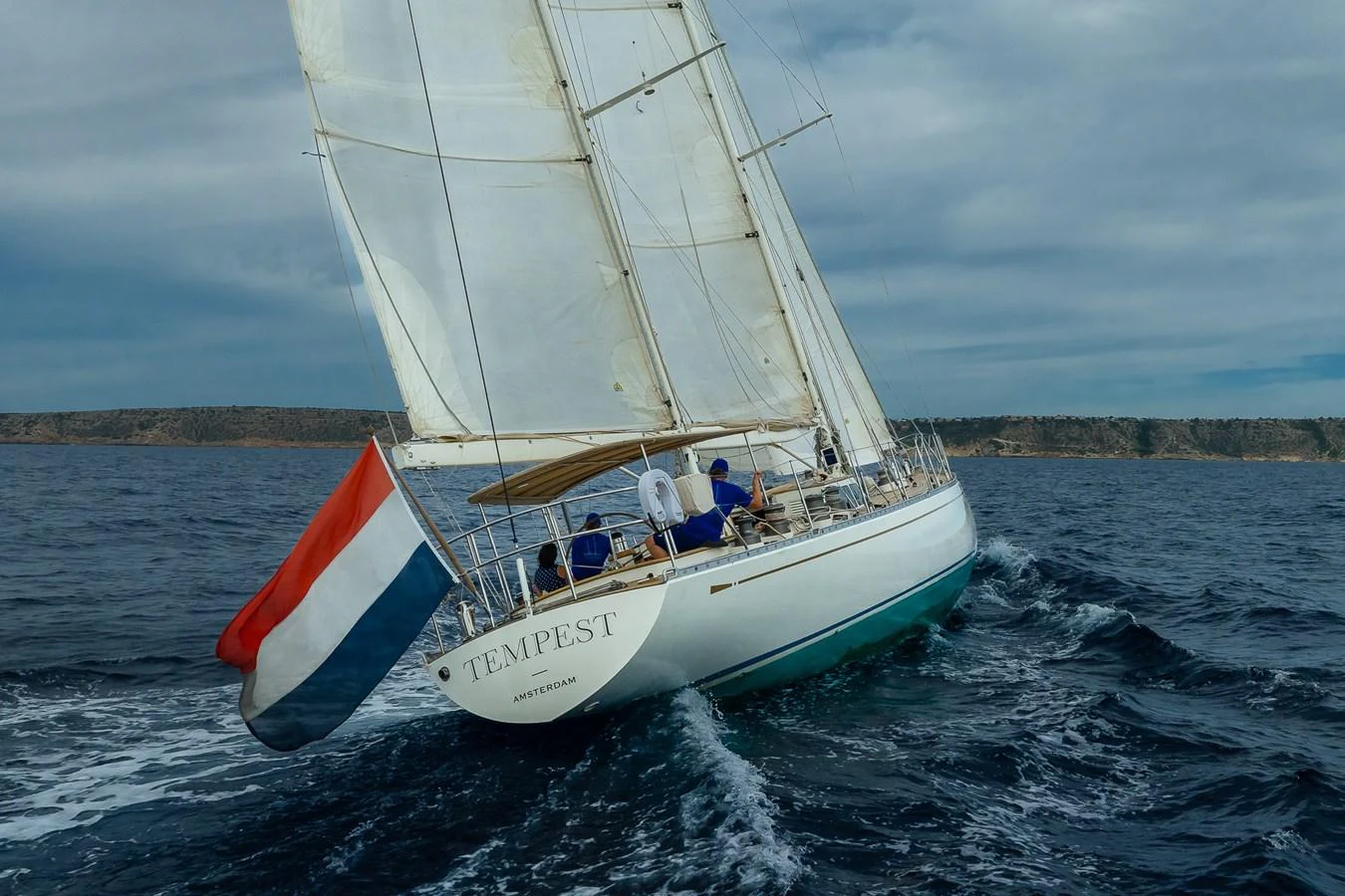 A sleek sailing yacht navigates through the open sea, showcasing its elegant design and impressive sails. aboard TEMPEST Yacht for Sale