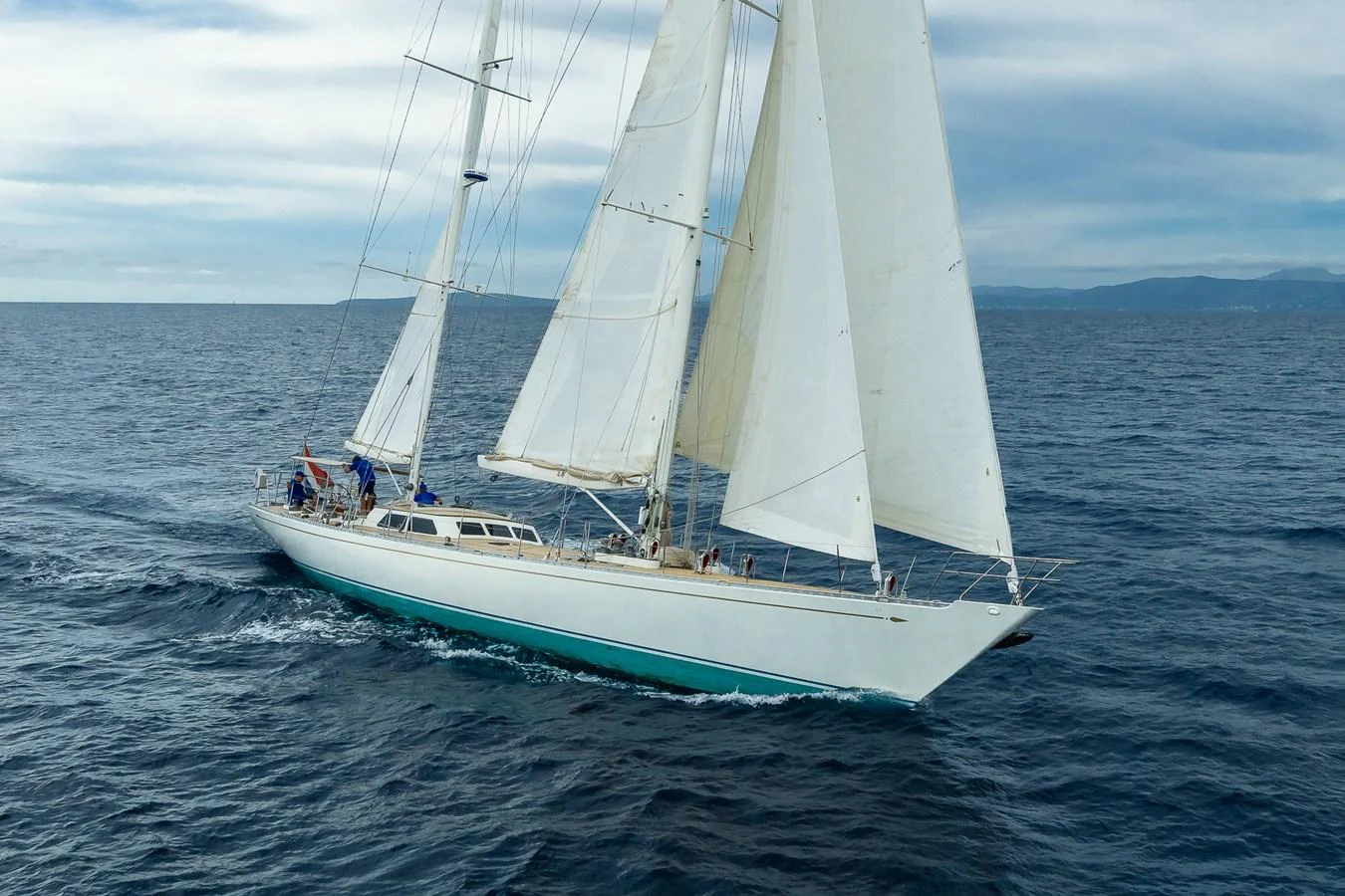 A sleek sailing yacht glides gracefully across the open sea under full sail. aboard TEMPEST Yacht for Sale