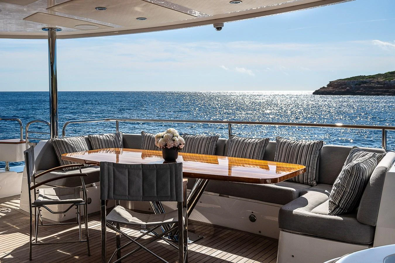 The aft deck features a stylish dining area with a stunning ocean view. aboard THIS TIME NEXT YEAR Yacht for Sale