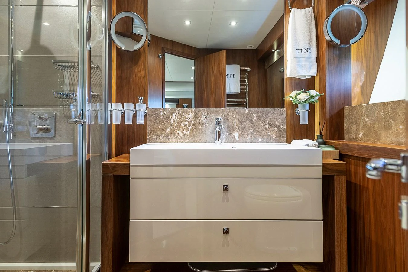 The yacht's bathroom features elegant wood paneling and a modern sink area. aboard THIS TIME NEXT YEAR Yacht for Sale