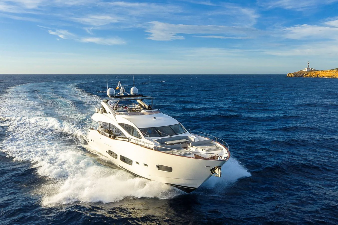 A luxurious yacht cruises swiftly through the open sea under a clear blue sky. aboard THIS TIME NEXT YEAR Yacht for Sale
