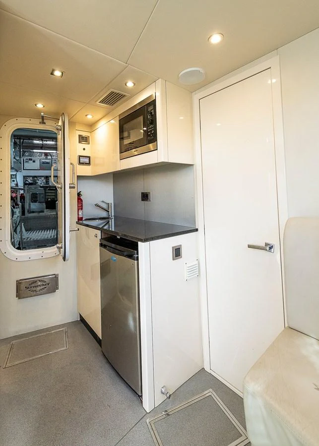 The compact galley features modern appliances and sleek cabinetry, providing a functional and stylish space for meal preparation. aboard THIS TIME NEXT YEAR Yacht for Sale