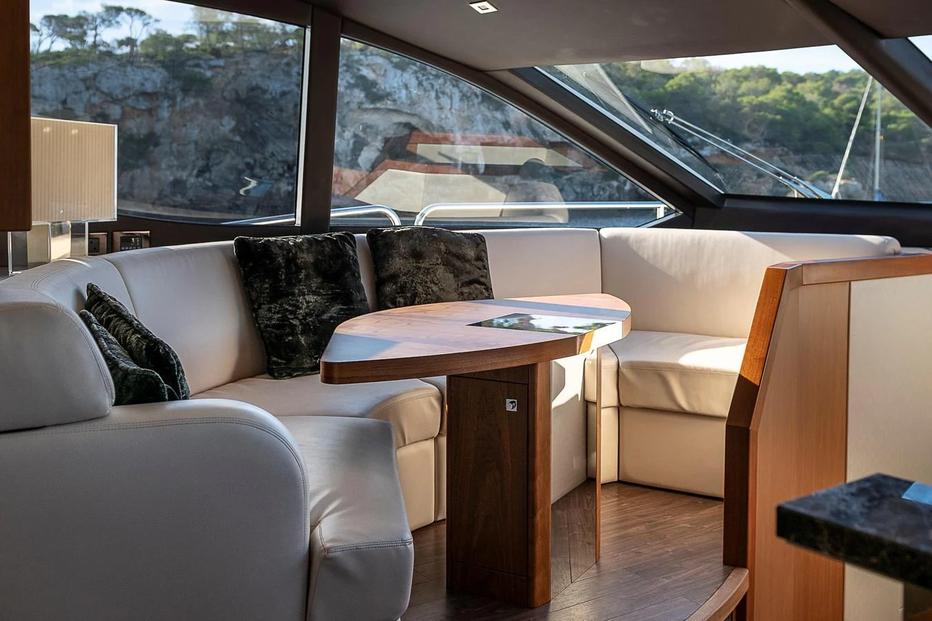 The yacht's salon features a cozy seating area with large windows offering scenic views. aboard THIS TIME NEXT YEAR Yacht for Sale