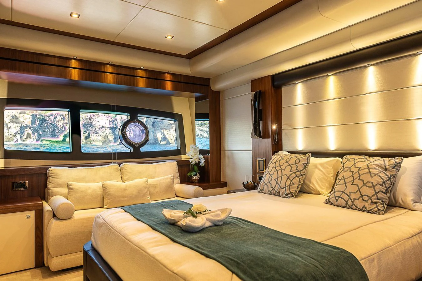 The master stateroom features a luxurious bed, comfortable seating, and large windows offering stunning views. aboard THIS TIME NEXT YEAR Yacht for Sale