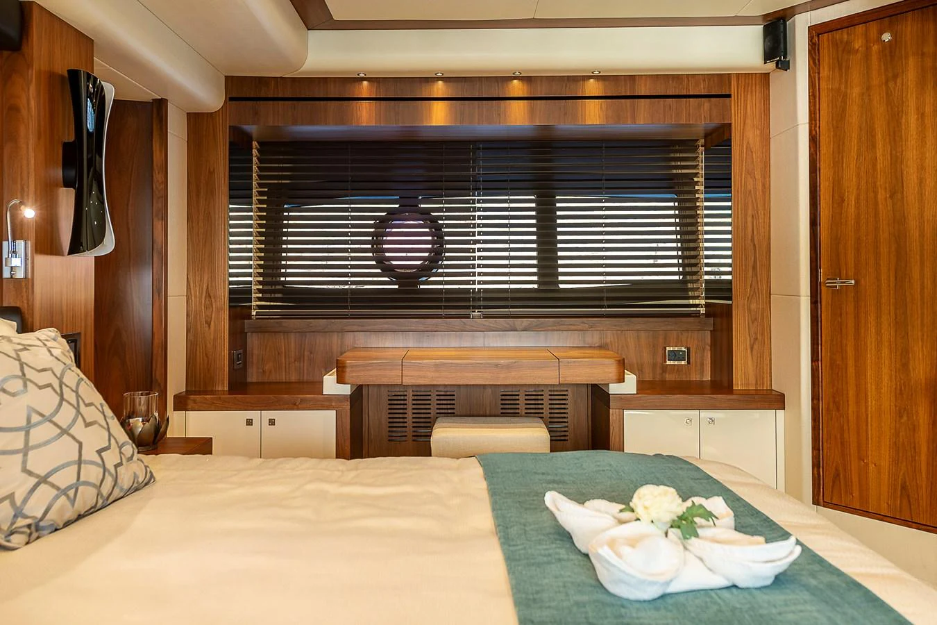 The stateroom features elegant wood paneling and a cozy ambiance with a neatly made bed and stylish decor. aboard THIS TIME NEXT YEAR Yacht for Sale