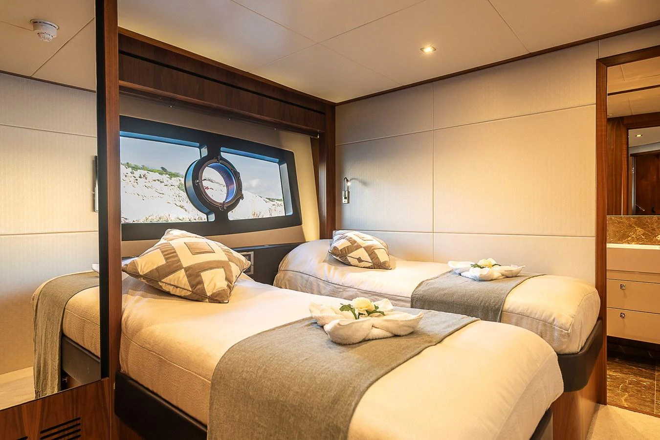 The guest stateroom features twin beds with elegant bedding and a large window offering scenic views. aboard THIS TIME NEXT YEAR Yacht for Sale