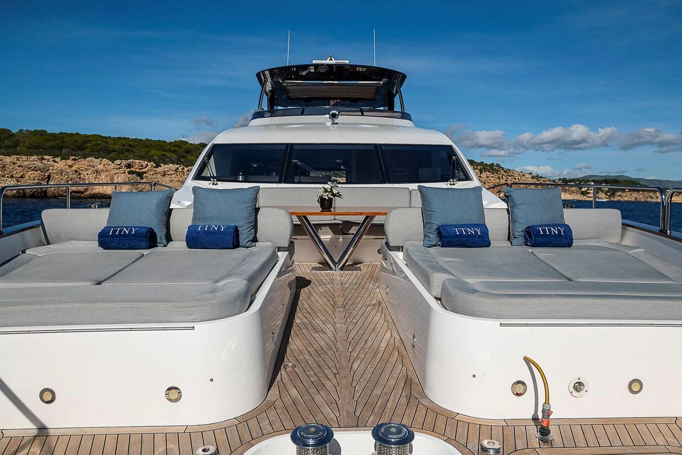 The aft deck of this yacht features luxurious sun loungers and a stylish seating area, perfect for relaxation. aboard THIS TIME NEXT YEAR Yacht for Sale