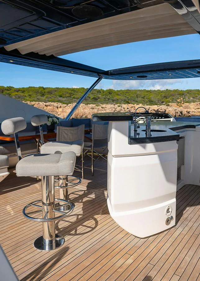 The flybridge features a sleek bar area with comfortable seating and a stunning view. aboard THIS TIME NEXT YEAR Yacht for Sale