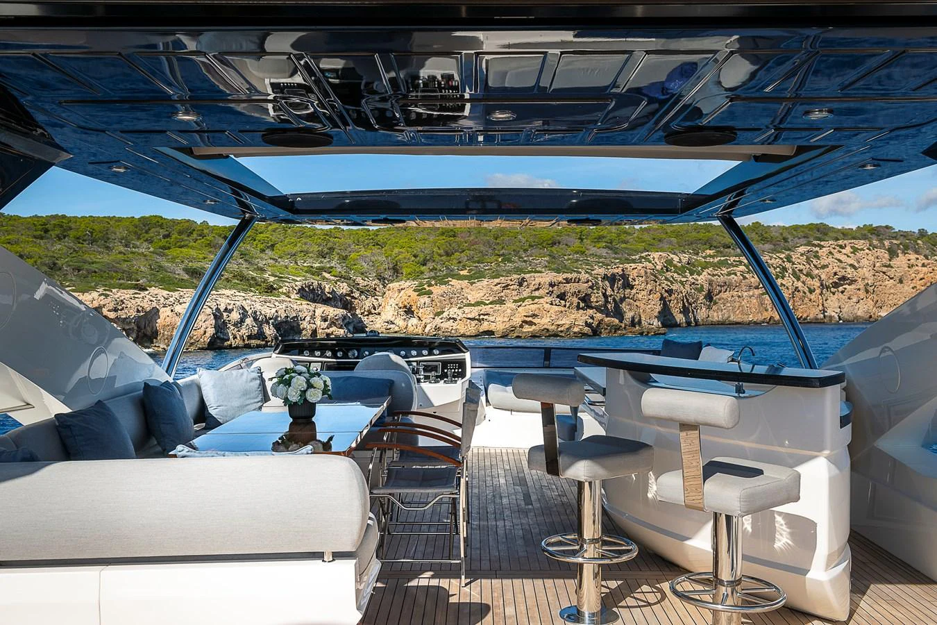 The aft deck offers a luxurious outdoor seating area with a bar and stunning views of the surrounding landscape. aboard THIS TIME NEXT YEAR Yacht for Sale