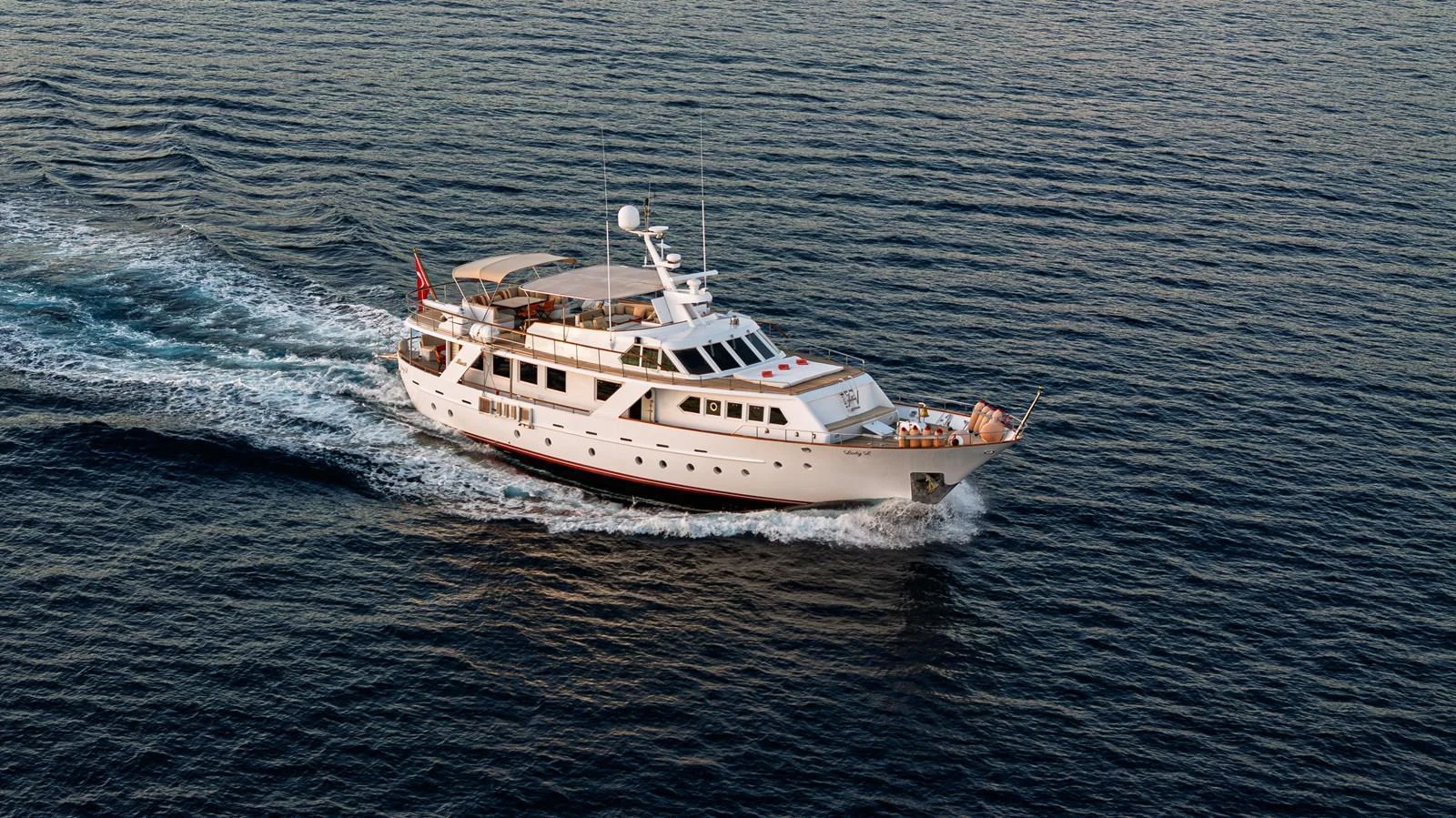 A classic motor yacht cruises smoothly on open waters, showcasing its elegant design and spacious decks. aboard LADY L Yacht for Sale