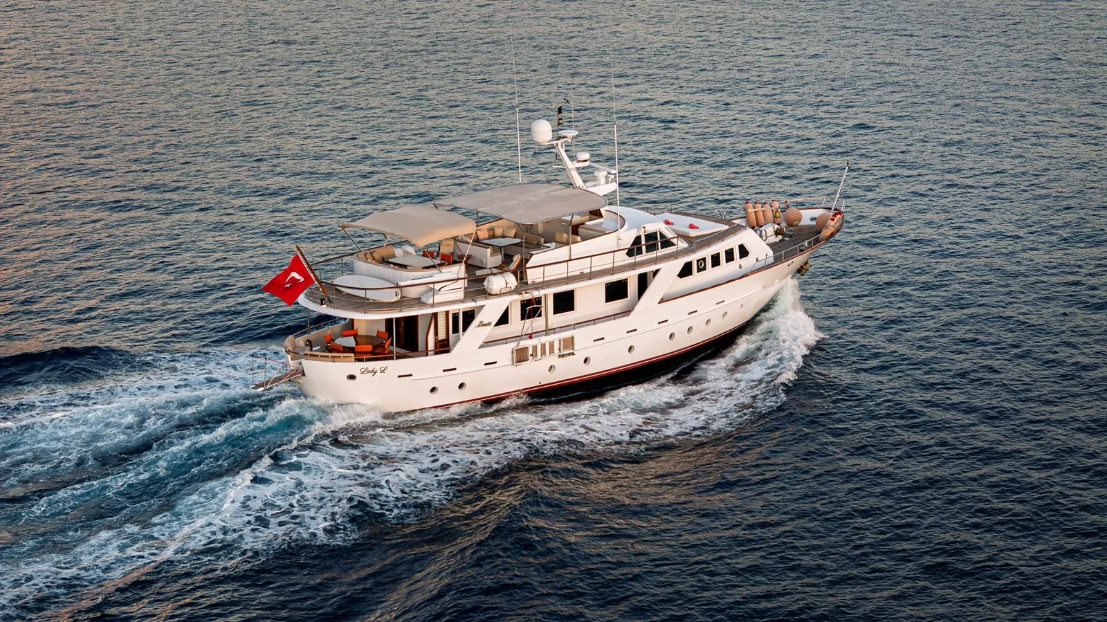 A luxurious yacht cruises gracefully on the open sea, showcasing its elegant design and spacious decks. aboard LADY L Yacht for Sale