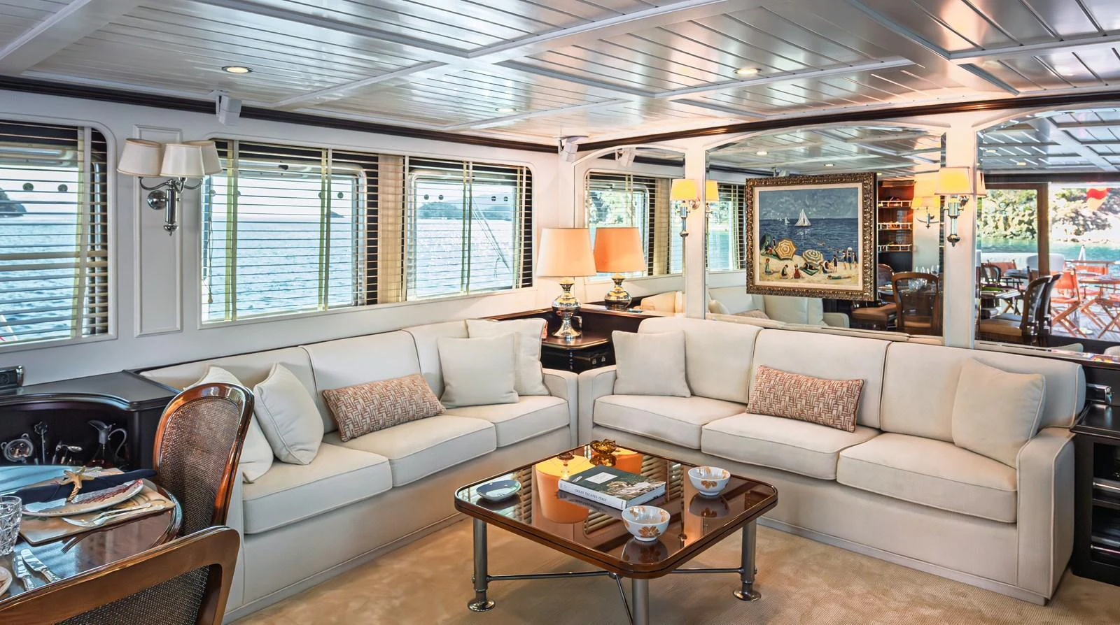 The salon features plush seating and elegant decor with ample natural light. aboard LADY L Yacht for Sale