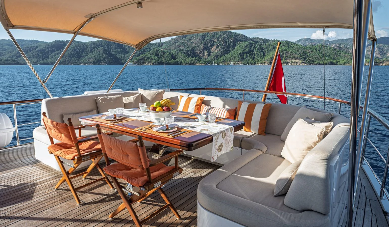 The aft deck features a comfortable dining area with plush seating and a stunning view of the surrounding waters. aboard LADY L Yacht for Sale