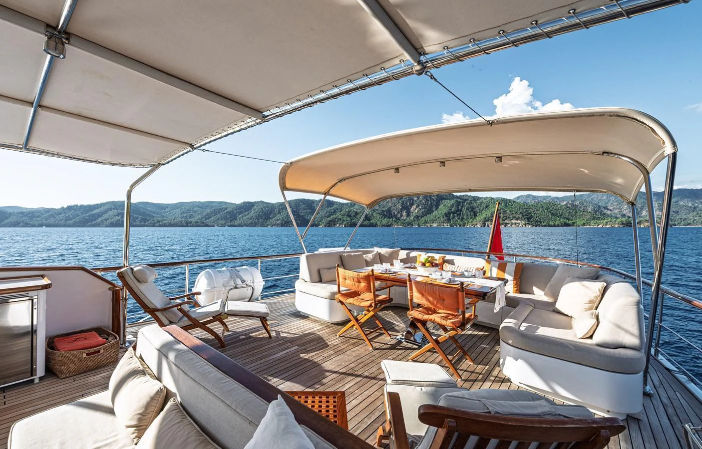The aft deck features a spacious seating area with a dining table, perfect for alfresco dining and relaxation. aboard LADY L Yacht for Sale