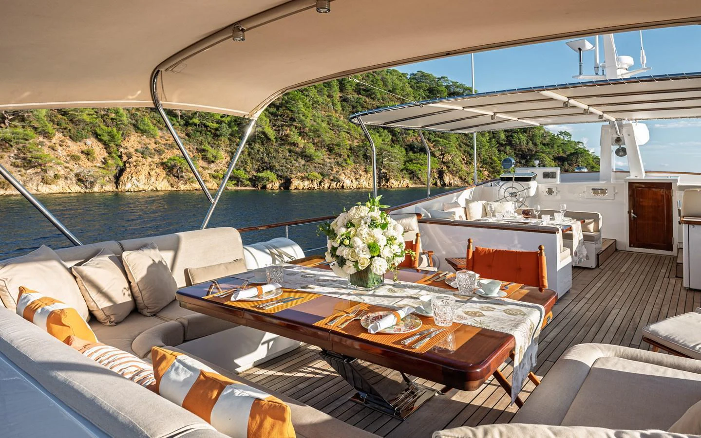The aft deck features a luxurious outdoor dining area with comfortable seating and scenic views. aboard LADY L Yacht for Sale