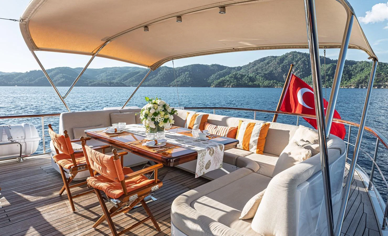 The aft deck features a spacious and elegantly set dining area with comfortable seating and scenic views. aboard LADY L Yacht for Sale