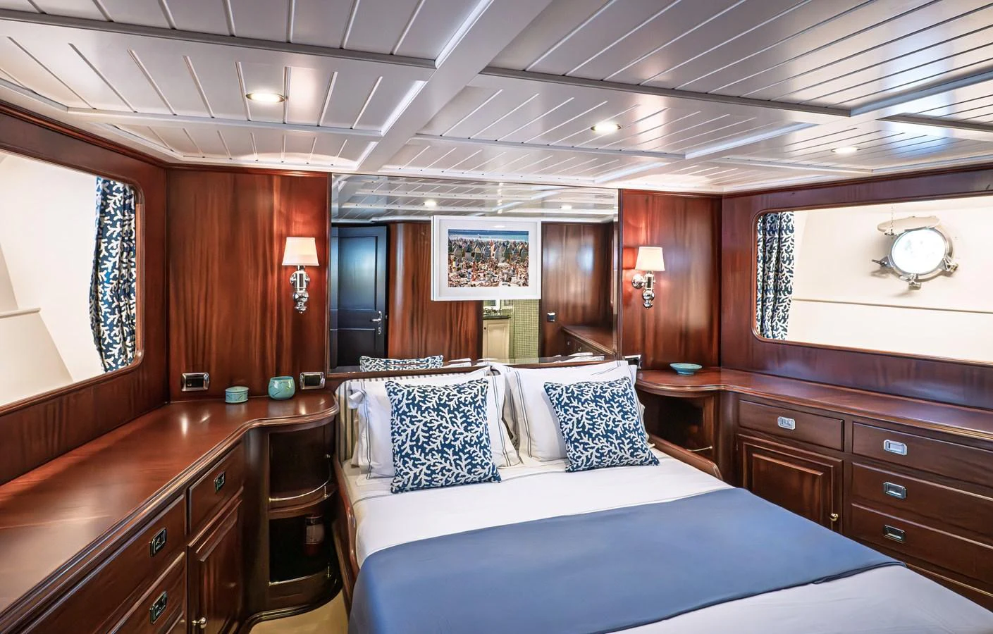 The stateroom features elegant wood paneling, plush bedding, and ample natural light. aboard LADY L Yacht for Sale
