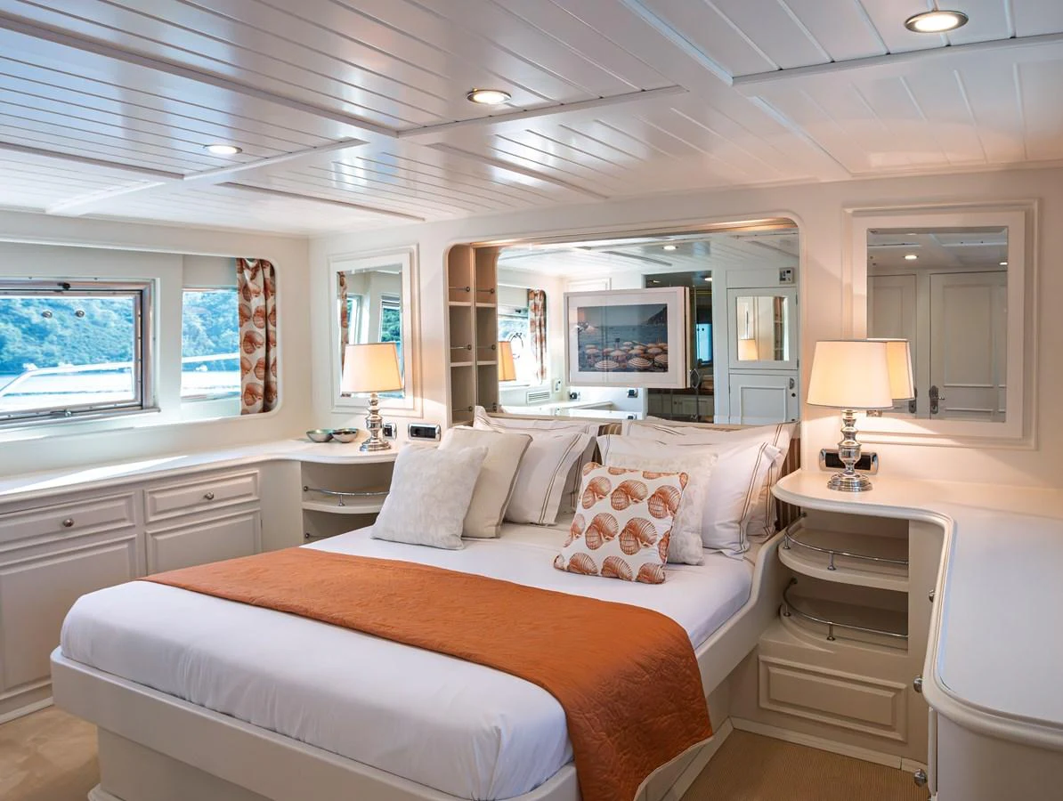 The master stateroom features elegant decor with ample natural light and luxurious bedding. aboard LADY L Yacht for Sale
