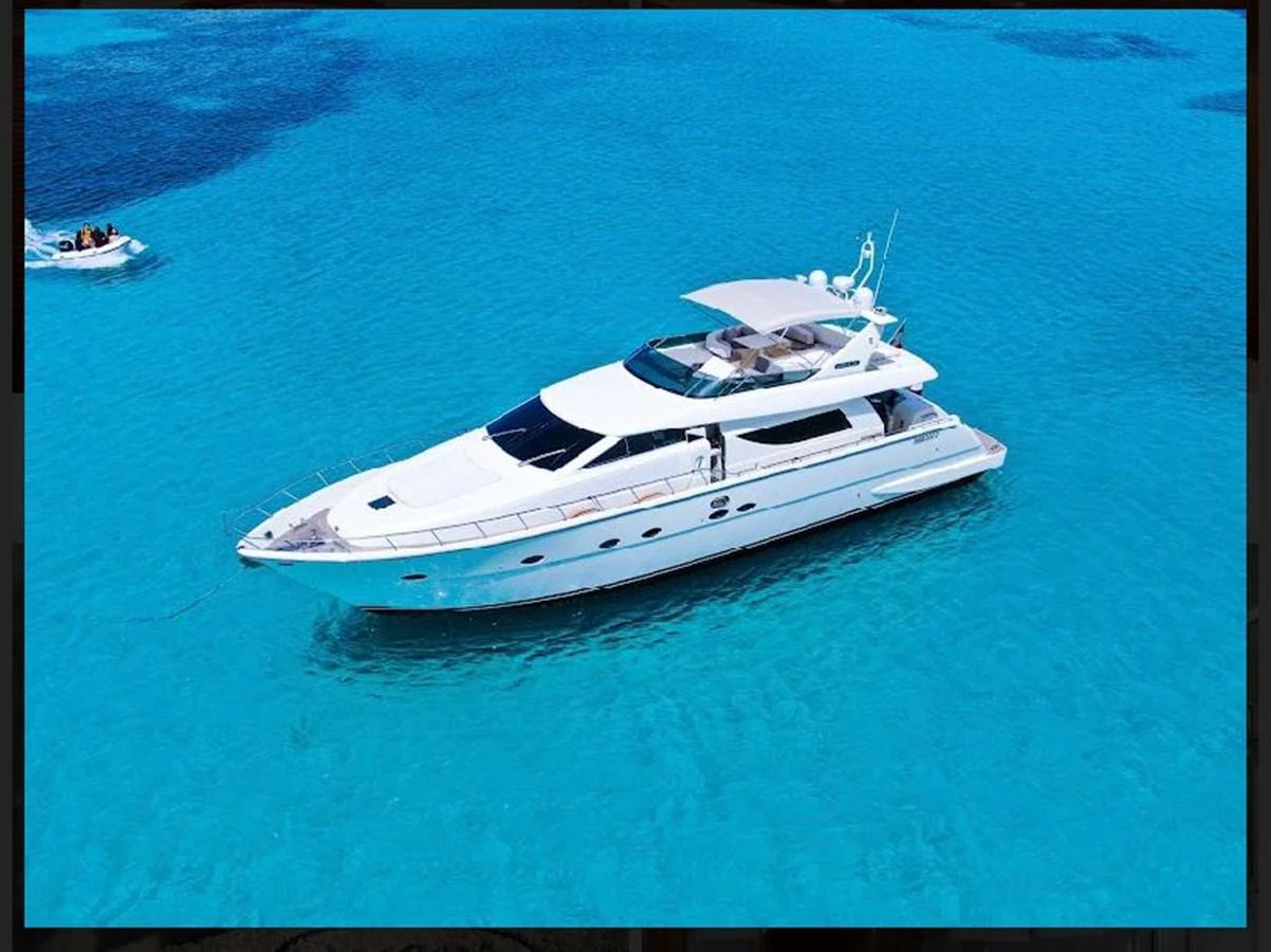 A sleek white yacht cruises through crystal-clear blue waters, showcasing its elegant design. aboard STRADIVARIA Yacht for Sale