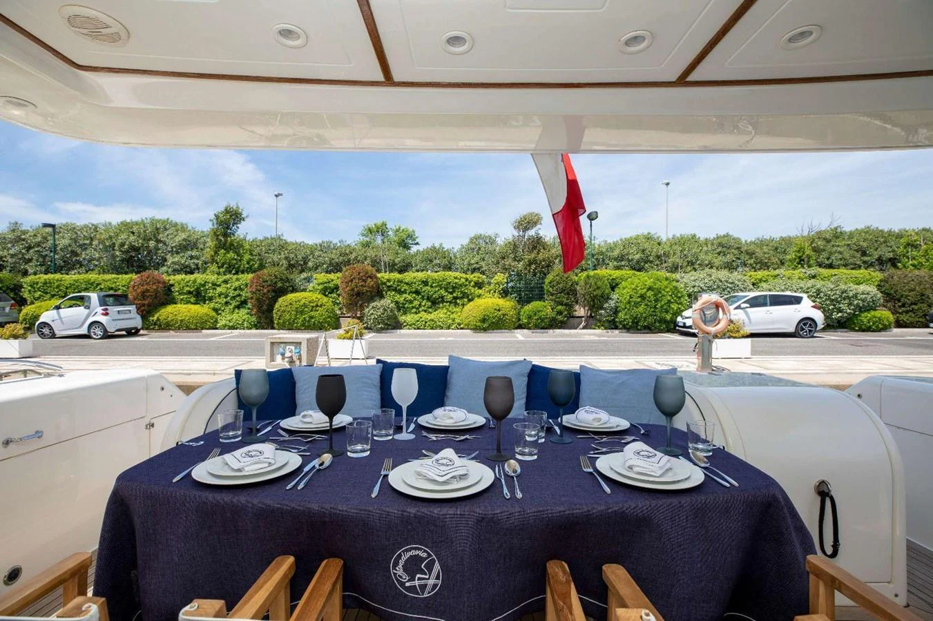 The aft deck features an elegant dining setup with a view of the surrounding greenery. aboard STRADIVARIA Yacht for Sale