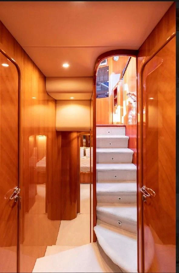 A luxurious interior staircase with polished wood paneling and soft carpeted steps. aboard STRADIVARIA Yacht for Sale