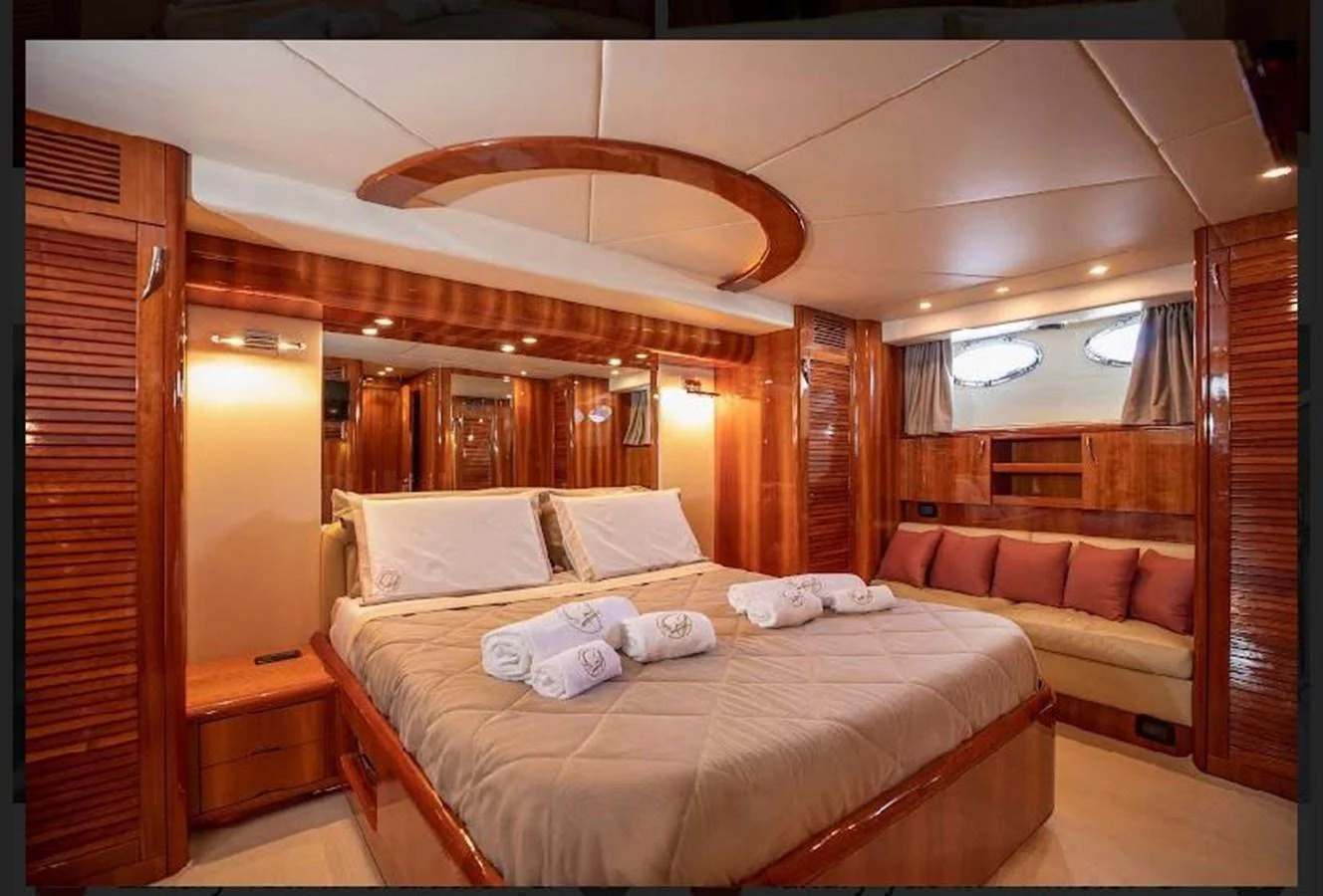 The master stateroom features a luxurious bed with plush linens and elegant wood finishes. aboard STRADIVARIA Yacht for Sale