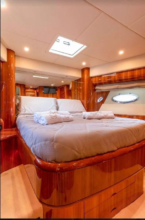 A luxurious stateroom featuring a comfortable bed with plush linens and warm wood finishes. aboard STRADIVARIA Yacht for Sale
