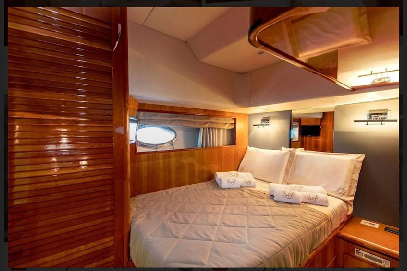 The stateroom features a cozy bed with elegant bedding and warm wooden accents. aboard STRADIVARIA Yacht for Sale