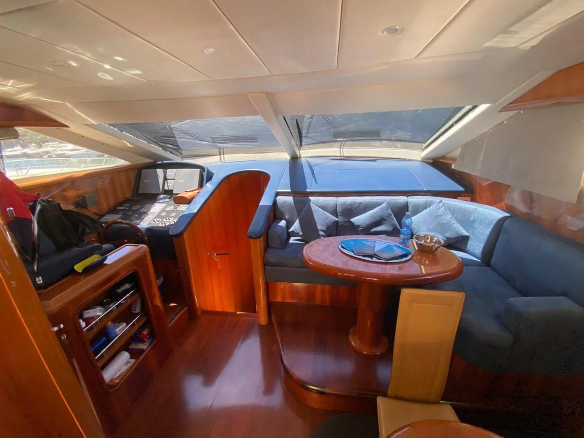 The helm area features a cozy seating arrangement with a wooden table and large windows offering ample natural light. aboard STRADIVARIA Yacht for Sale