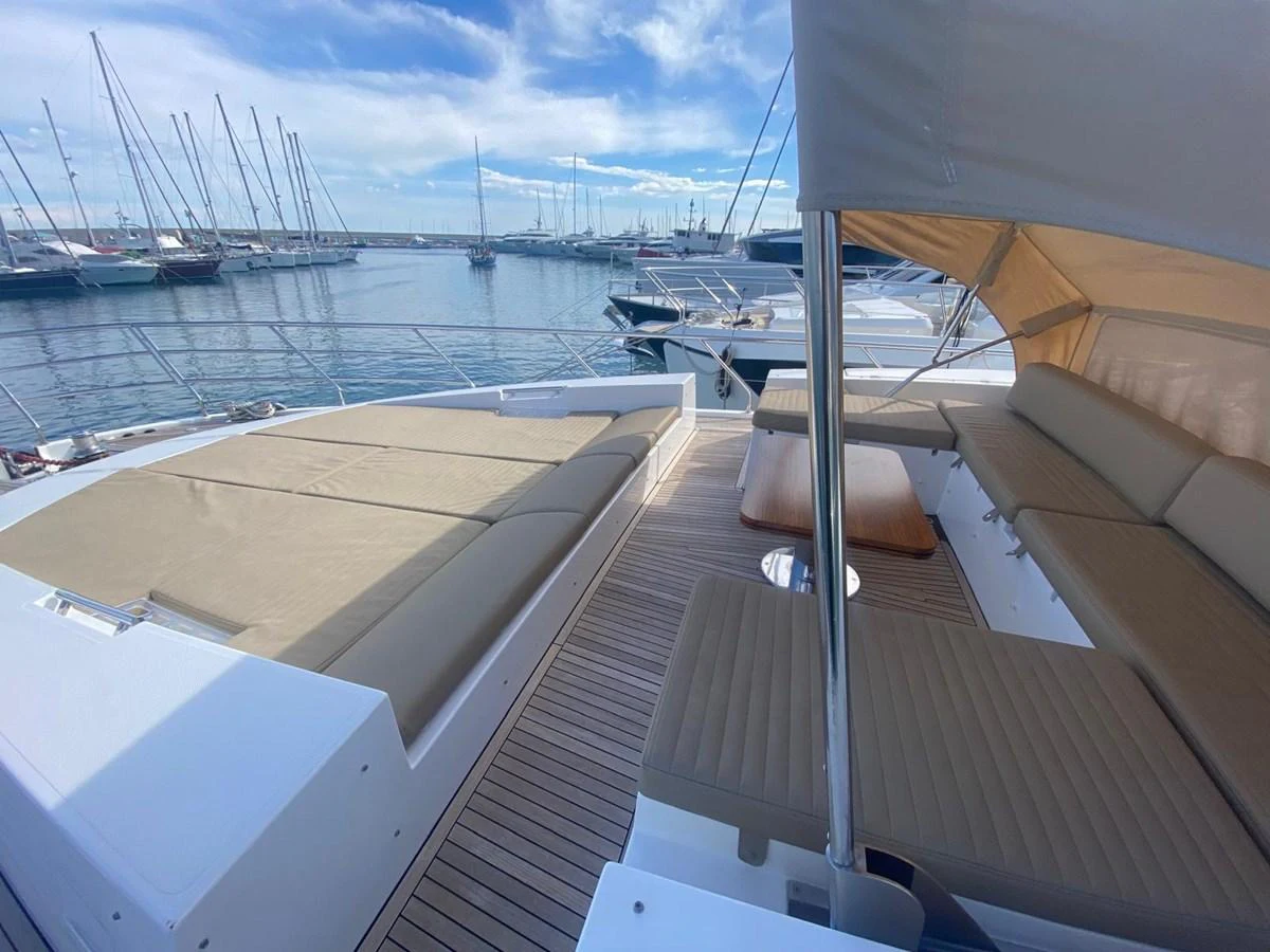 a deck with a boat and other boats in the water aboard 10009846 Yacht for Sale