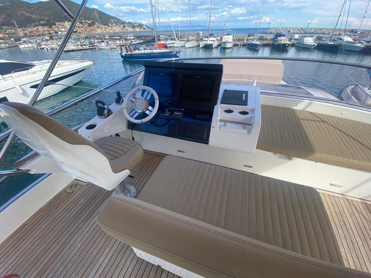 a deck with a boat and a large boat in the water aboard 10009846 Yacht for Sale
