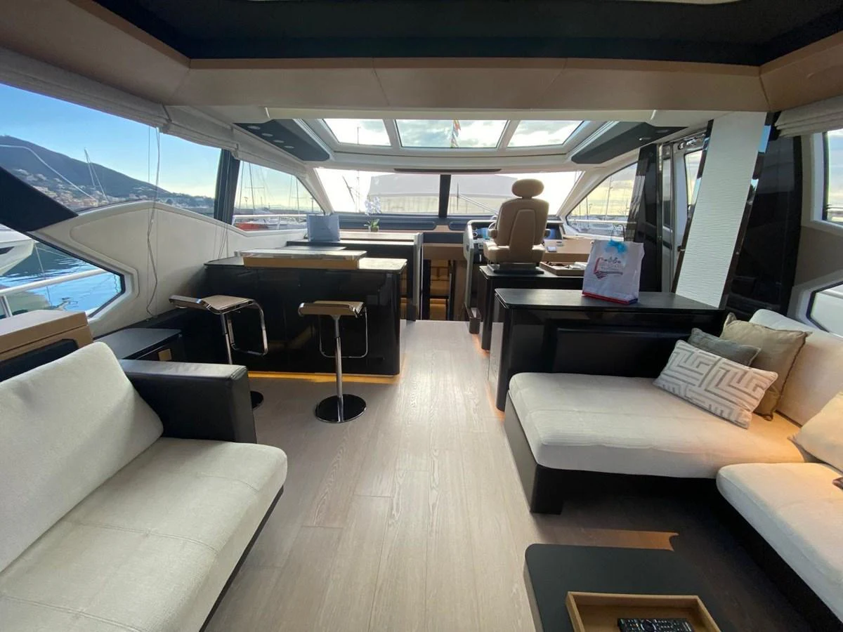 a person sitting in a chair in a room with a large window aboard 10009846 Yacht for Sale